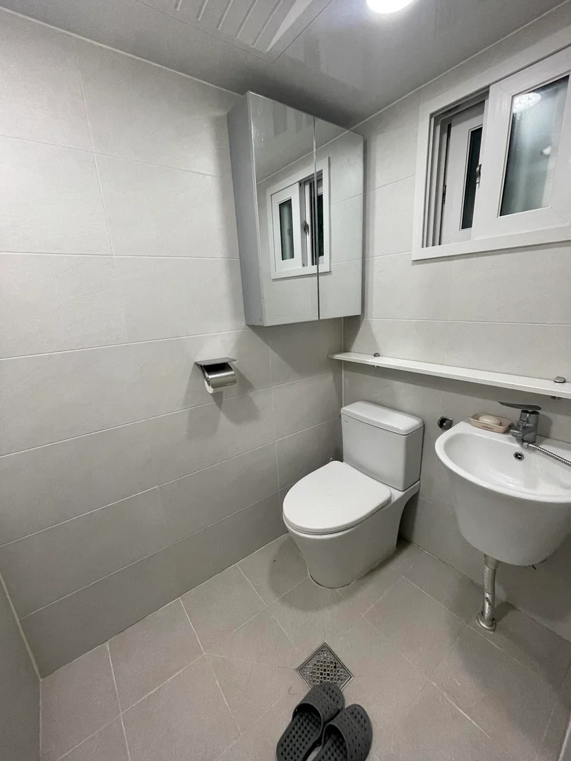 Tiled bathroom with a toilet, sink, and mirror cabinet (Listing ID : 22604)