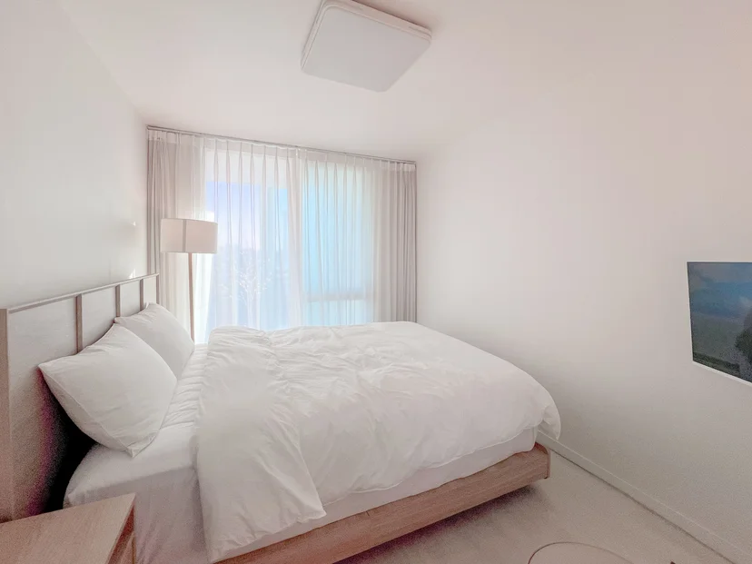 Bedroom with soft white bedding by a sunny window (Listing ID : 34458)