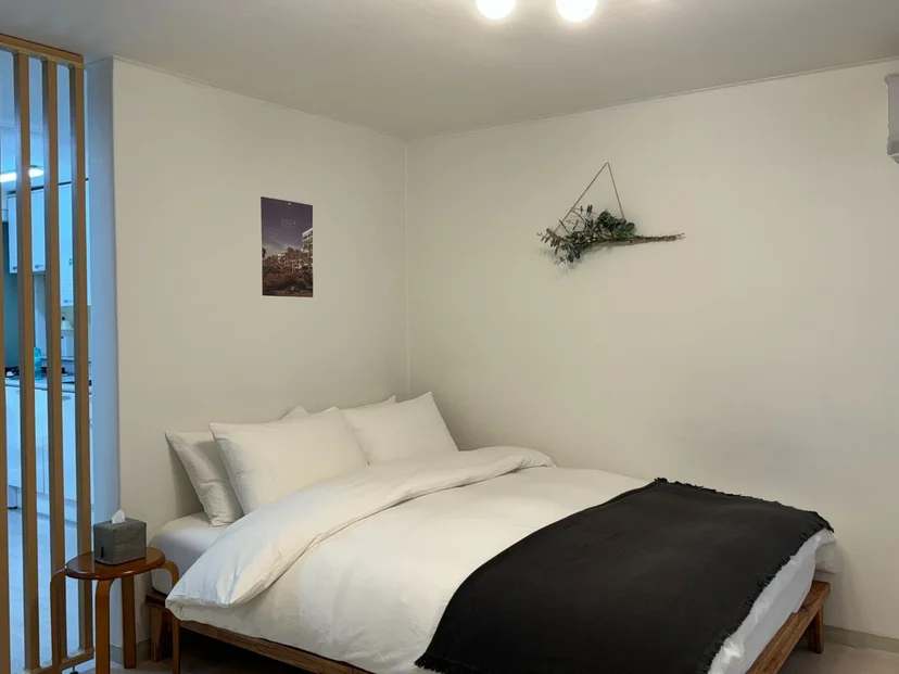 Bright sleeping area with a white-framed double bed and marble-look floor (Listing ID : 33170)