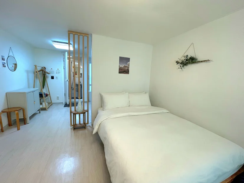 Cozy bed nook with a wooden divider, coat rack, and dried-flower wall decor (Listing ID : 33170)