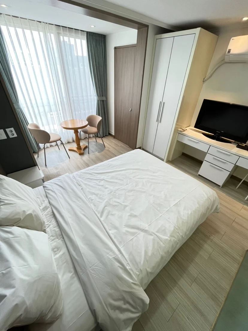 Bedroom with double bed, wardrobe, TV and small dining nook by window (Listing ID : 34007)