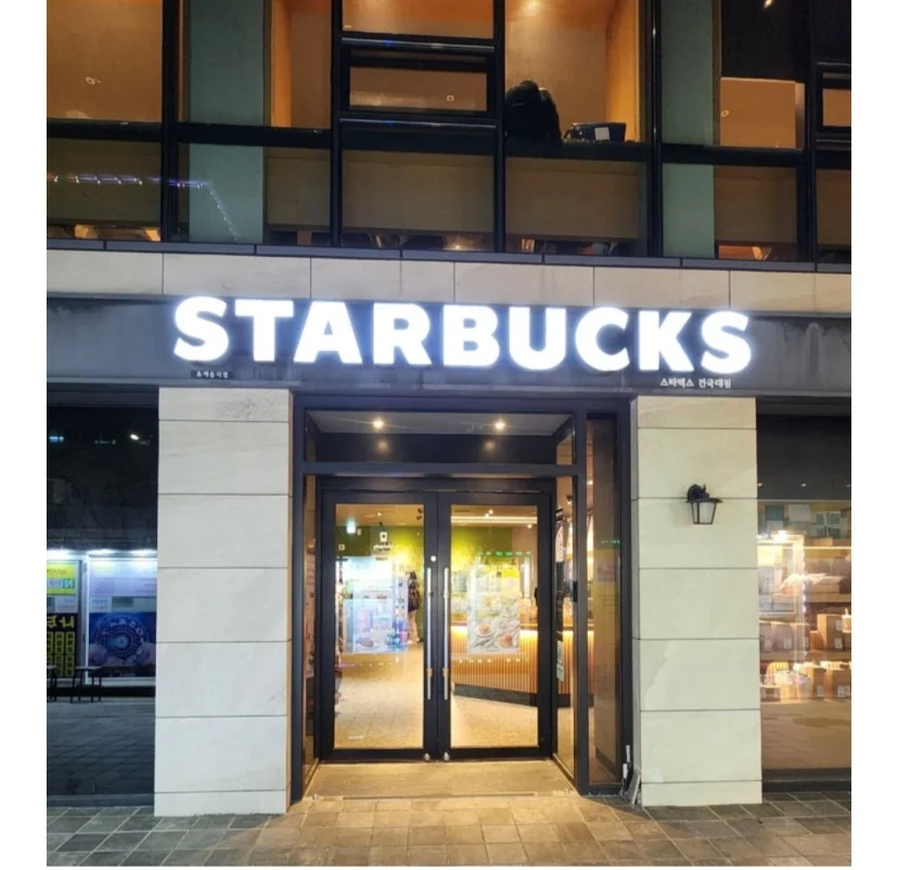 Starbucks storefront lit up at night near the stay (Listing ID : 46995)
