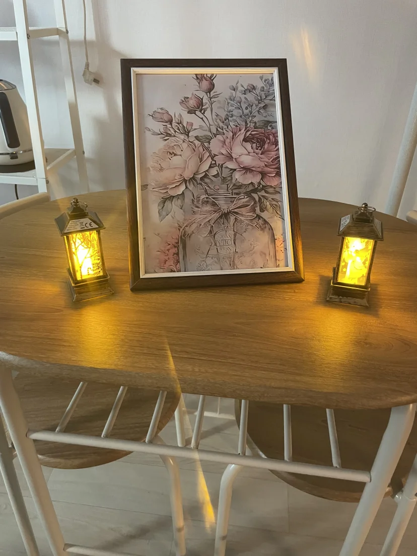 Round table with framed floral art and two lantern lamps (Listing ID : 46995)