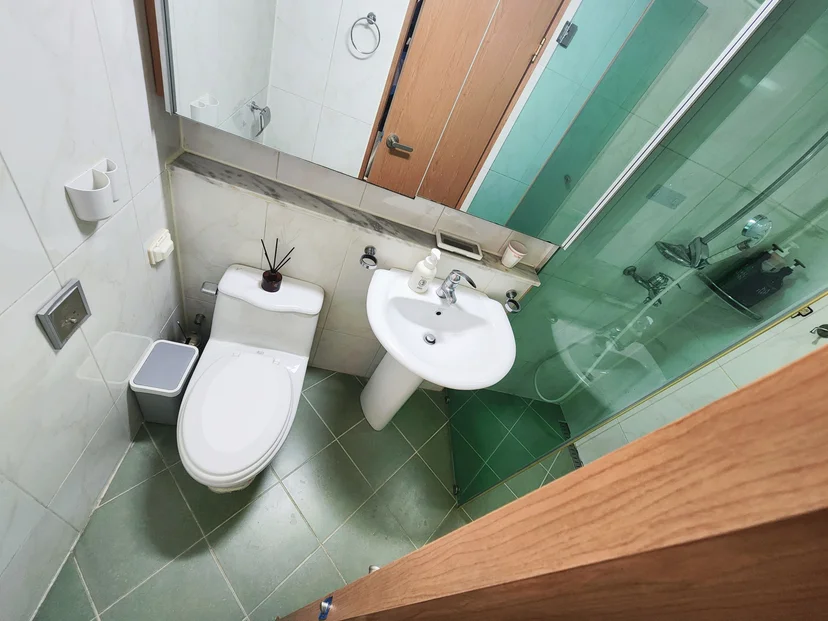 White toilet and pedestal sink in a tiled bathroom with glass shower partition (Listing ID : 44317)
