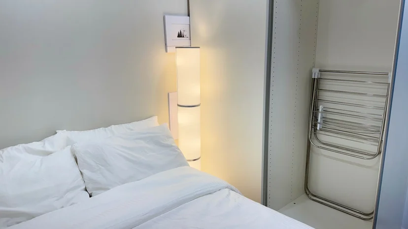 Sleeping area with bedding and a clothes drying rack (Listing ID : 30596)