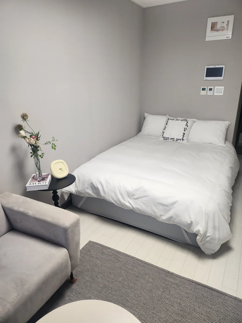포인트 쿠션이 놓인 화이트 침구 침대