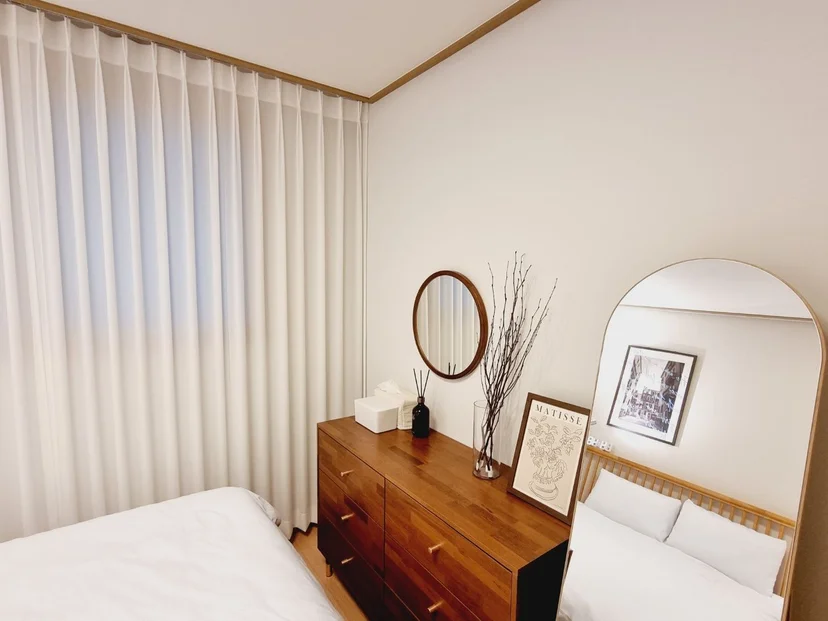 Bedroom corner with a dresser and arched floor mirror (Listing ID : 32182)