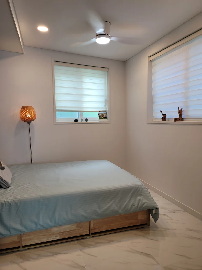 Second bedroom with a wood-frame bed and bright windows (Listing ID : 41157)