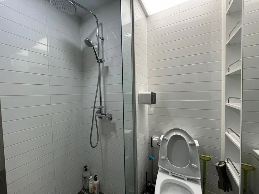White-tiled bathroom with a glass shower and toilet (Listing ID : 35960)