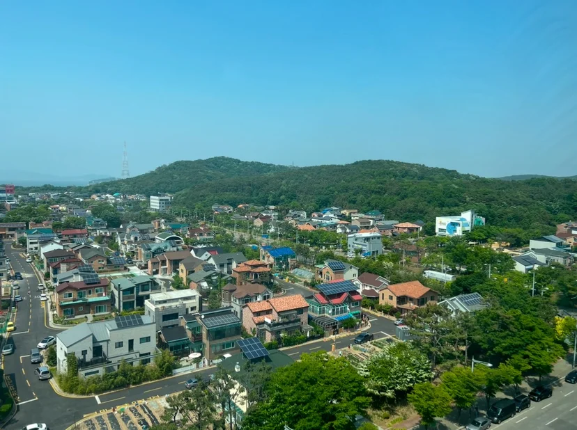 Daytime view over a low-rise village and green hills (Listing ID : 35960)