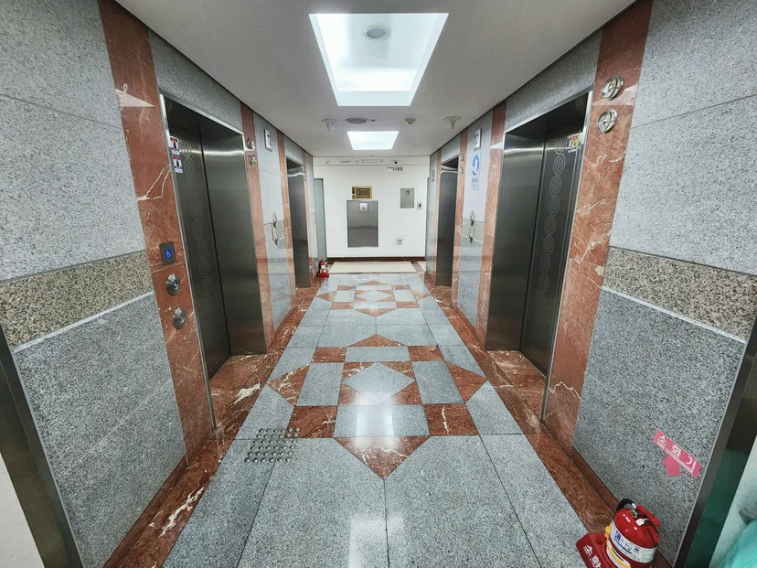 Interior elevator lobby with patterned stone floor and twin elevators (Listing ID : 44317)