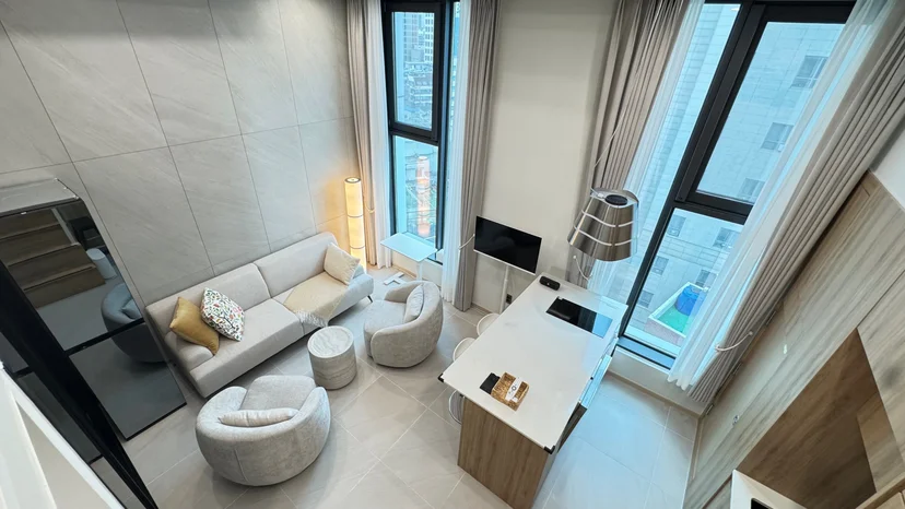 Overhead view of the living area with sofa and city-view windows (Listing ID : 30596)