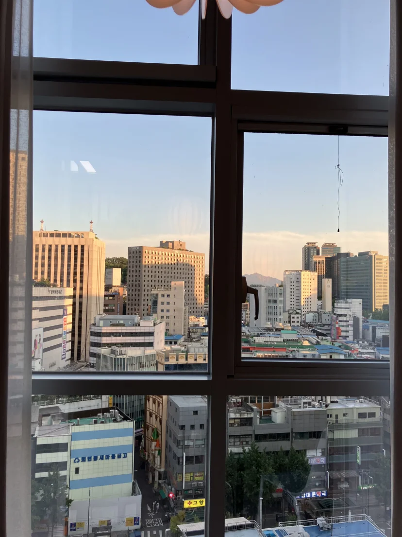 High-floor window view over central Seoul rooftops at dusk (Listing ID : 25414)