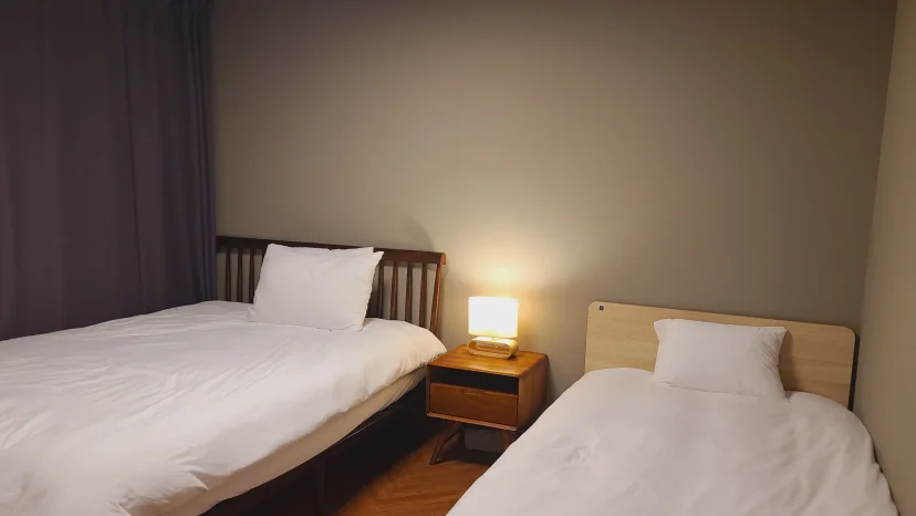 Bedroom with two single beds and a bedside lamp (Listing ID : 8342)