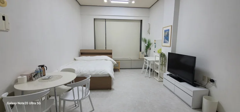 Studio with double bed, dining table, TV, and large window (Listing ID : 47450)