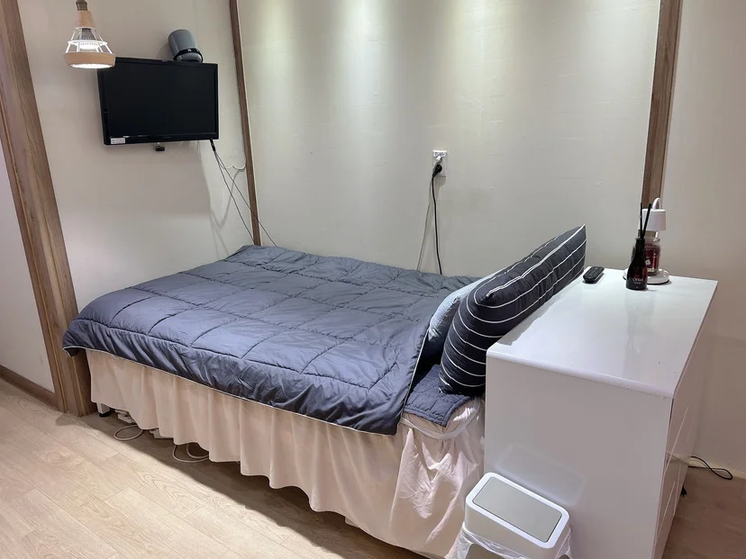 Sleeping area with a wall-mounted TV above the bed (Listing ID : 12332)