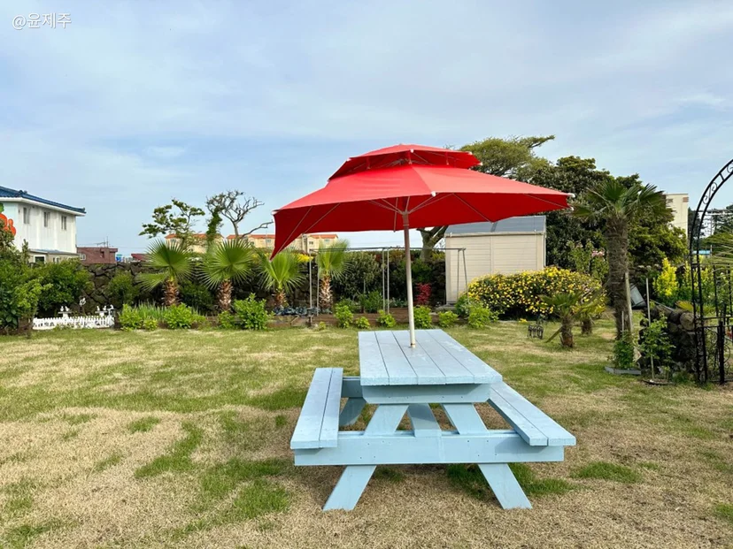 Picnic table under a red parasol on the lawn (Listing ID : 21118)