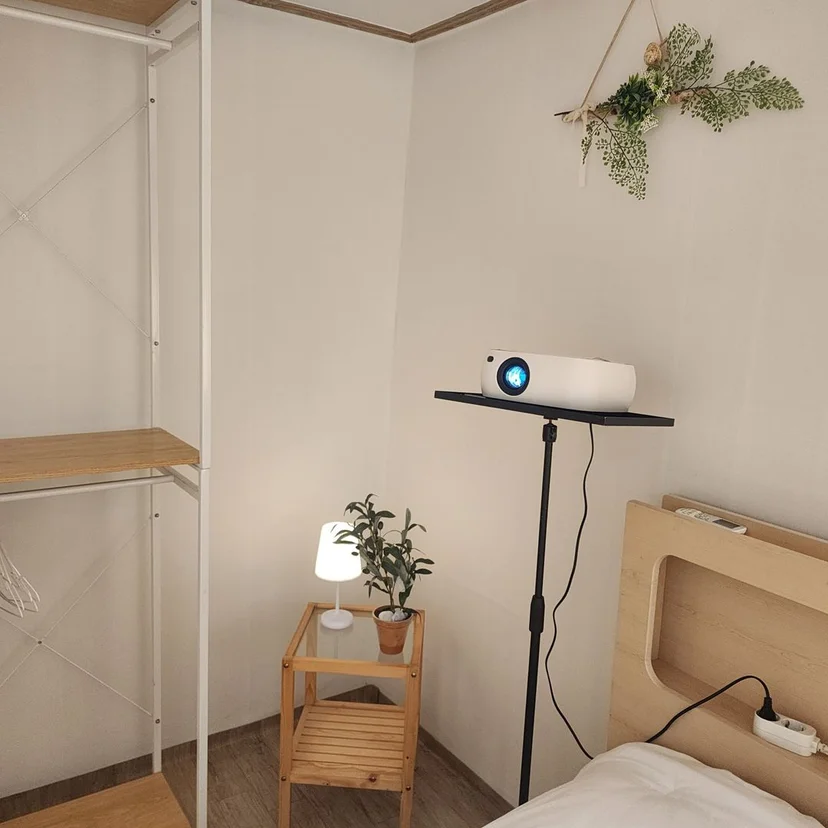 Bedroom corner with an open wardrobe rack and a reading lamp (Listing ID : 25853)