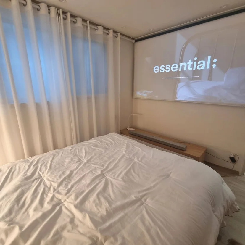 Bedroom with a projector screen and a low soundbar console (Listing ID : 25853)