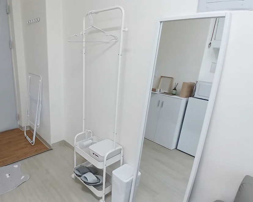Entryway corner with a clothes rack, full-length mirror, and amenity cart (Listing ID : 28802)