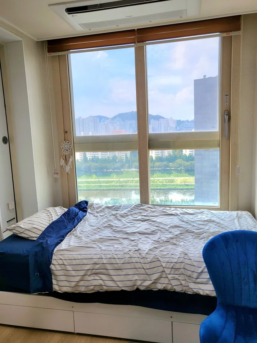 Bed by a wide window with hills and a stream beyond (Listing ID : 26920)