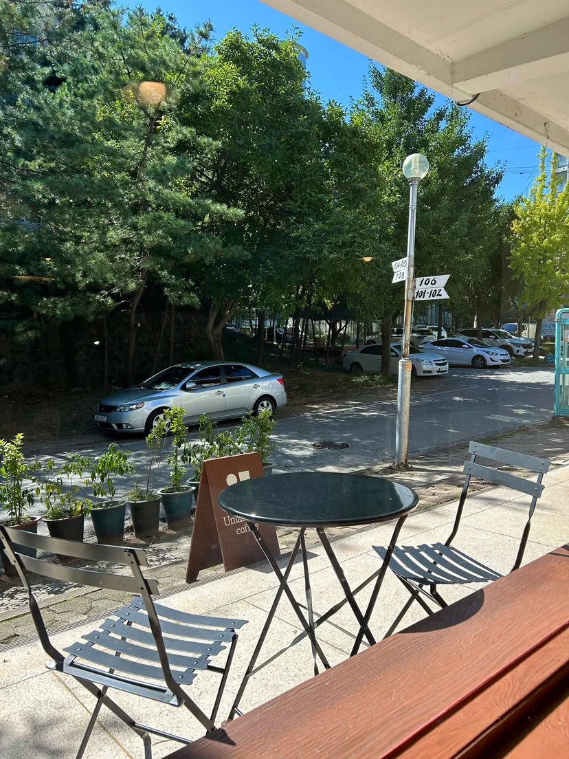 Tree-lined street with a cafe patio and parked cars outside (Listing ID : 30632)