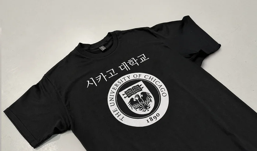 마플 커스텀 반팔 티셔츠 – 검은색 티셔츠 전면에 시카고대학교 영문명과 문장을 흰색으로 크게 인쇄해 펼쳐 놓은 이미지