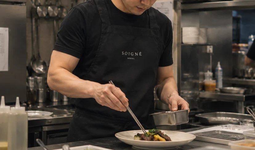 마플 AP 커스텀 앞치마 레스토랑 로고를 인쇄한 블랙 앞치마를 주방에서 착용하고 플레이팅하는 이미지