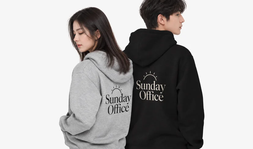 マープルのPrintstarオーバーフィット裏起毛ジップアップフーディー – 背面に「Sunday Office」例示ロゴを入れたグレーとブラックの男女スタジオ着用画像