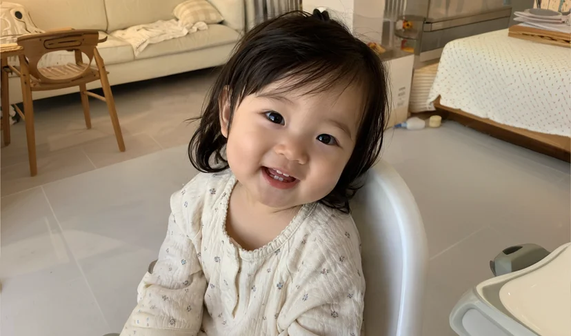 마플 아기 커스텀 굿즈 제작용 사진 – 실내에서 카메라를 바라보며 웃고 있는 여자 아기 원본 사진