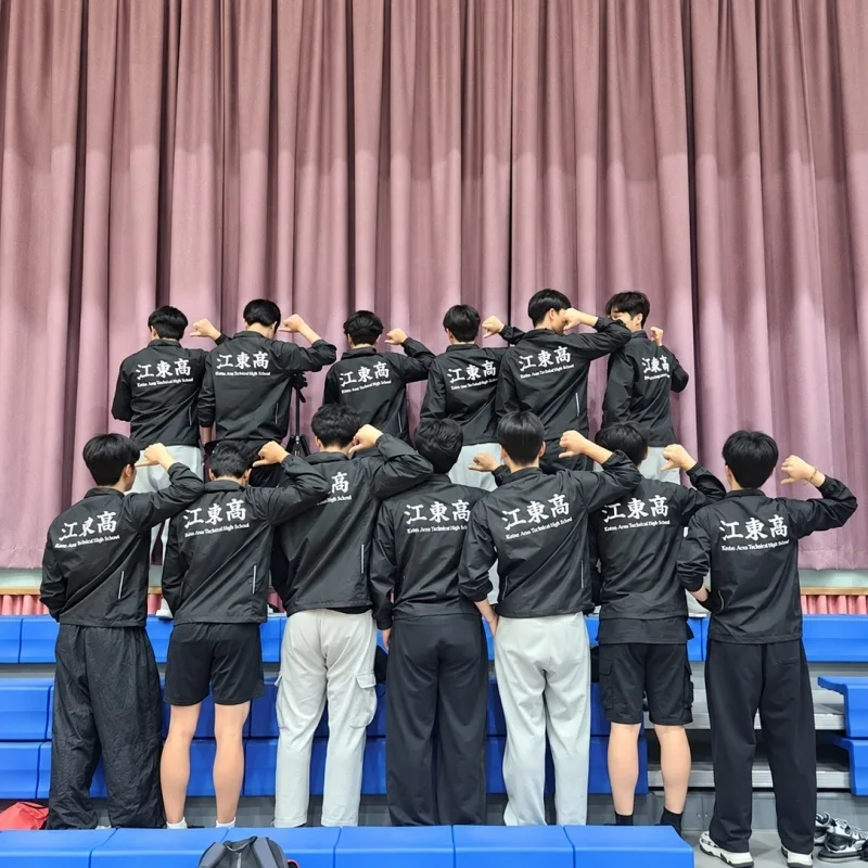 마플 학교 단체 바람막이 – 학교명과 레터링을 등판에 흰색으로 프린팅한 블랙 바람막이를 맞춰 입은 학생 단체 이미지