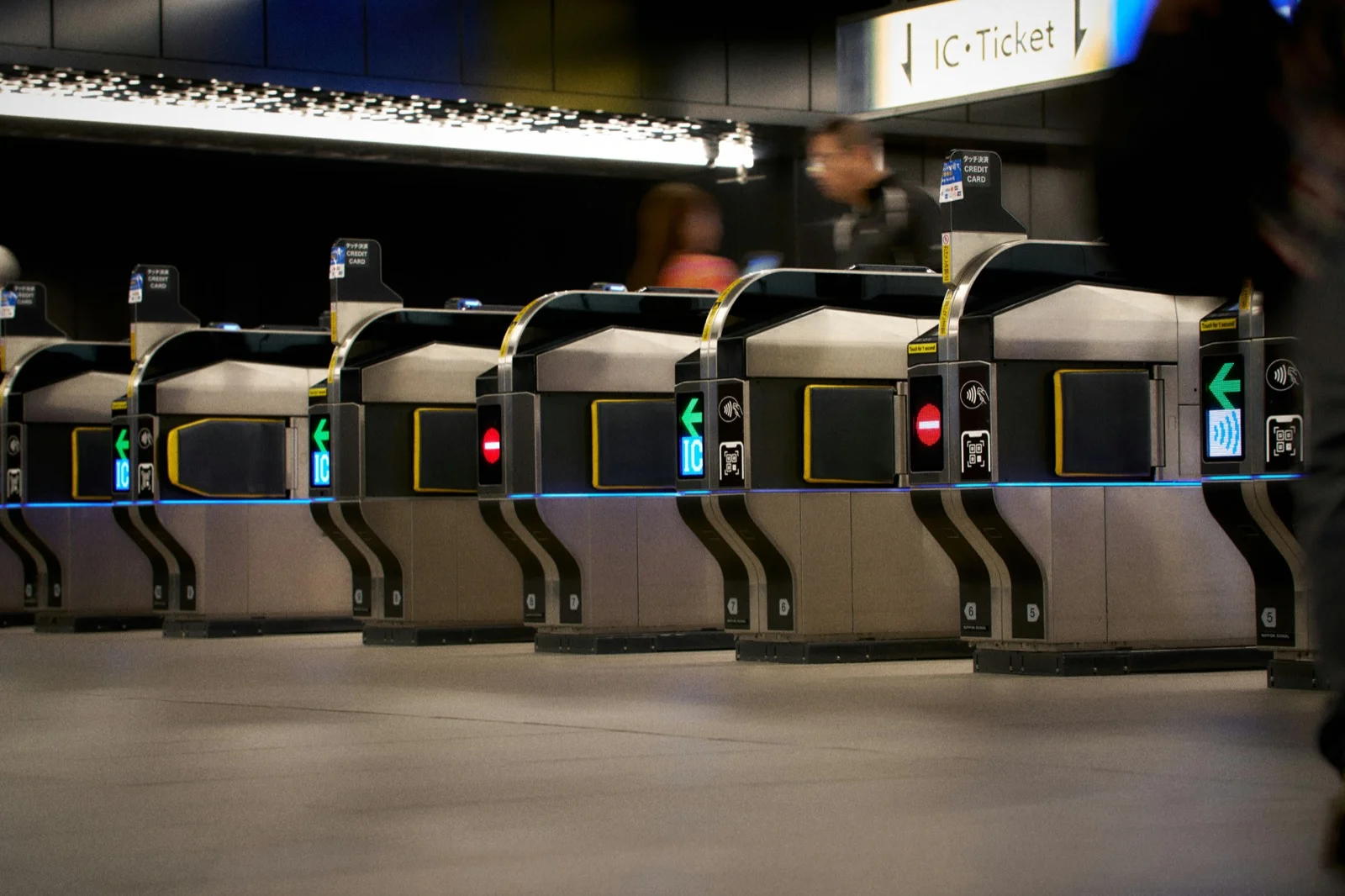 Row of ticket gates in a modern subway station where passengers tap their T-money transit cards to enter