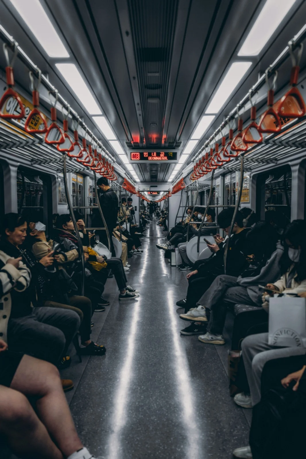 Passengers sitting inside a Korean subway train, demonstrating typical commuter etiquette